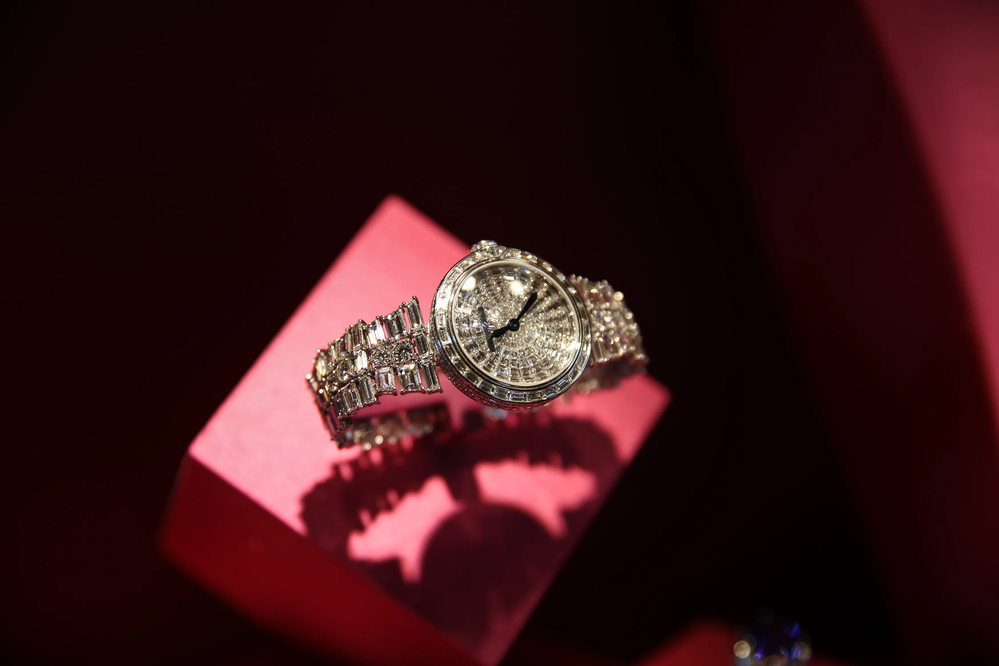 Diamond watch on a pink cube under red light