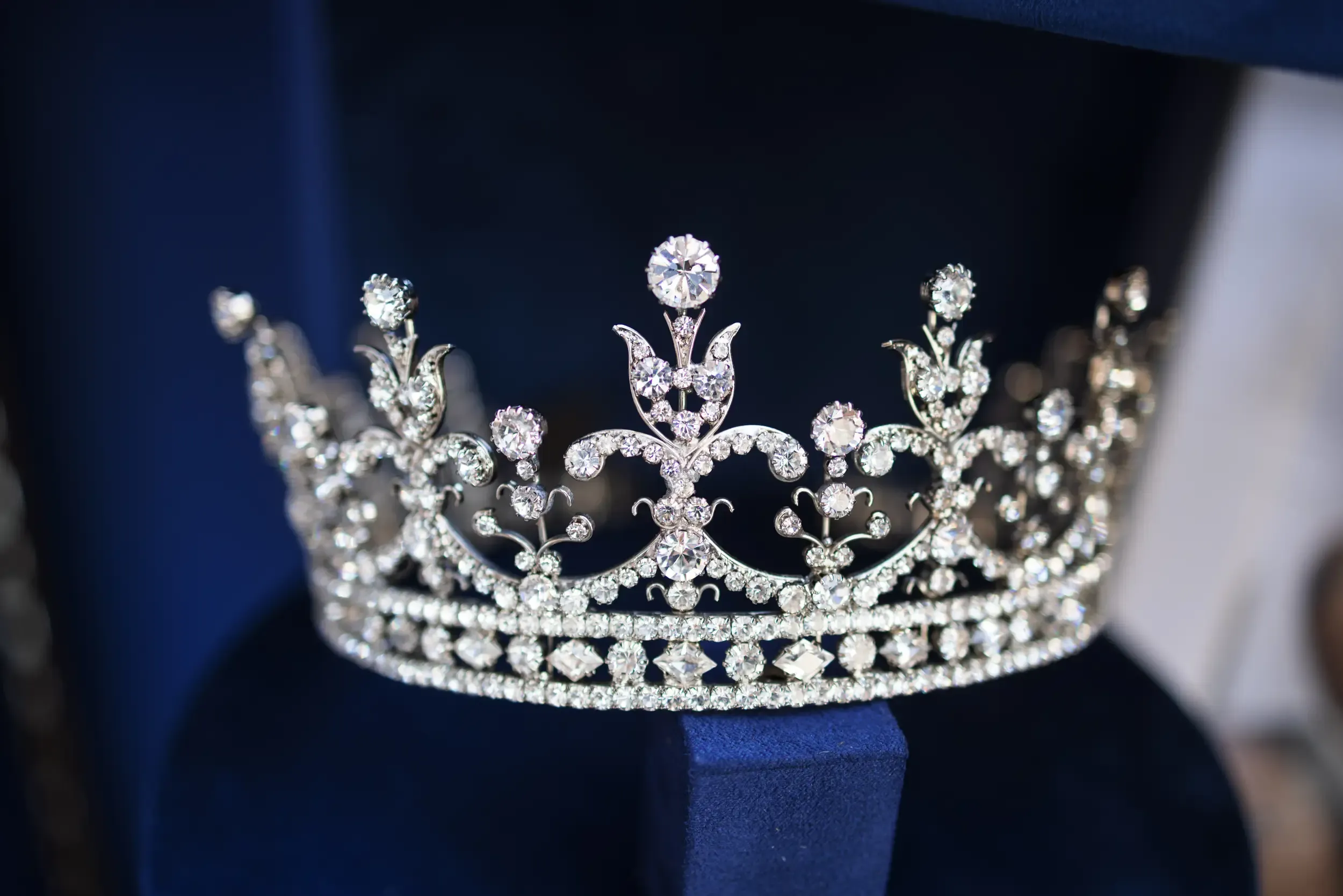 Ornate diamond tiara on a navy velvet stand, product detail for a luxury jewelry event