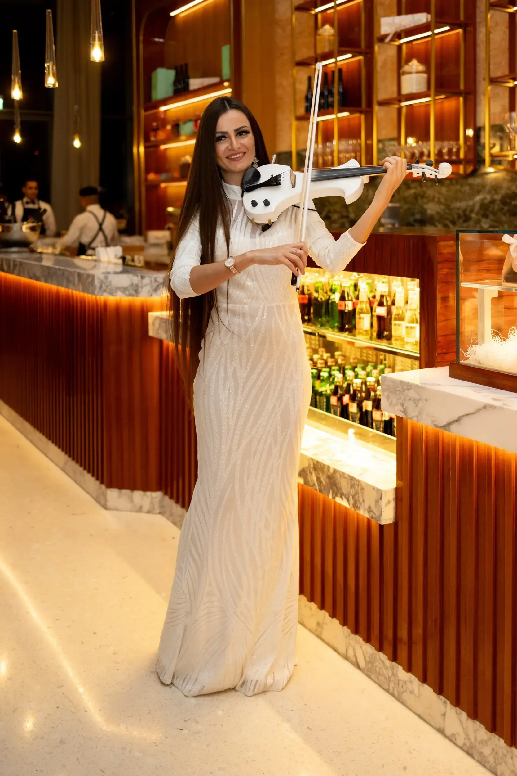Electric violinist in a shimmering white gown performing in a luxury lounge bar