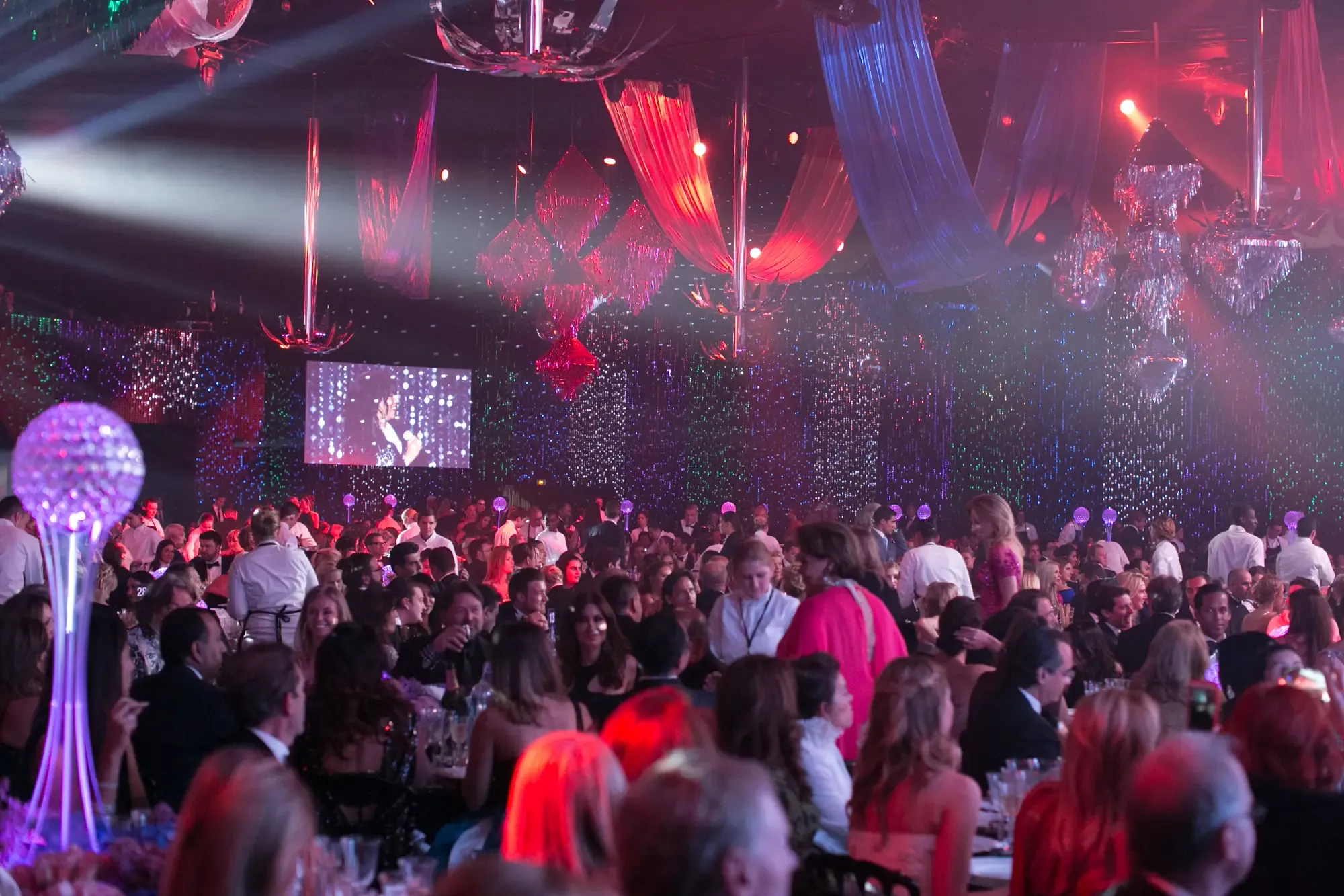 A packed gala ballroom in Dubai under coloured ceiling lights