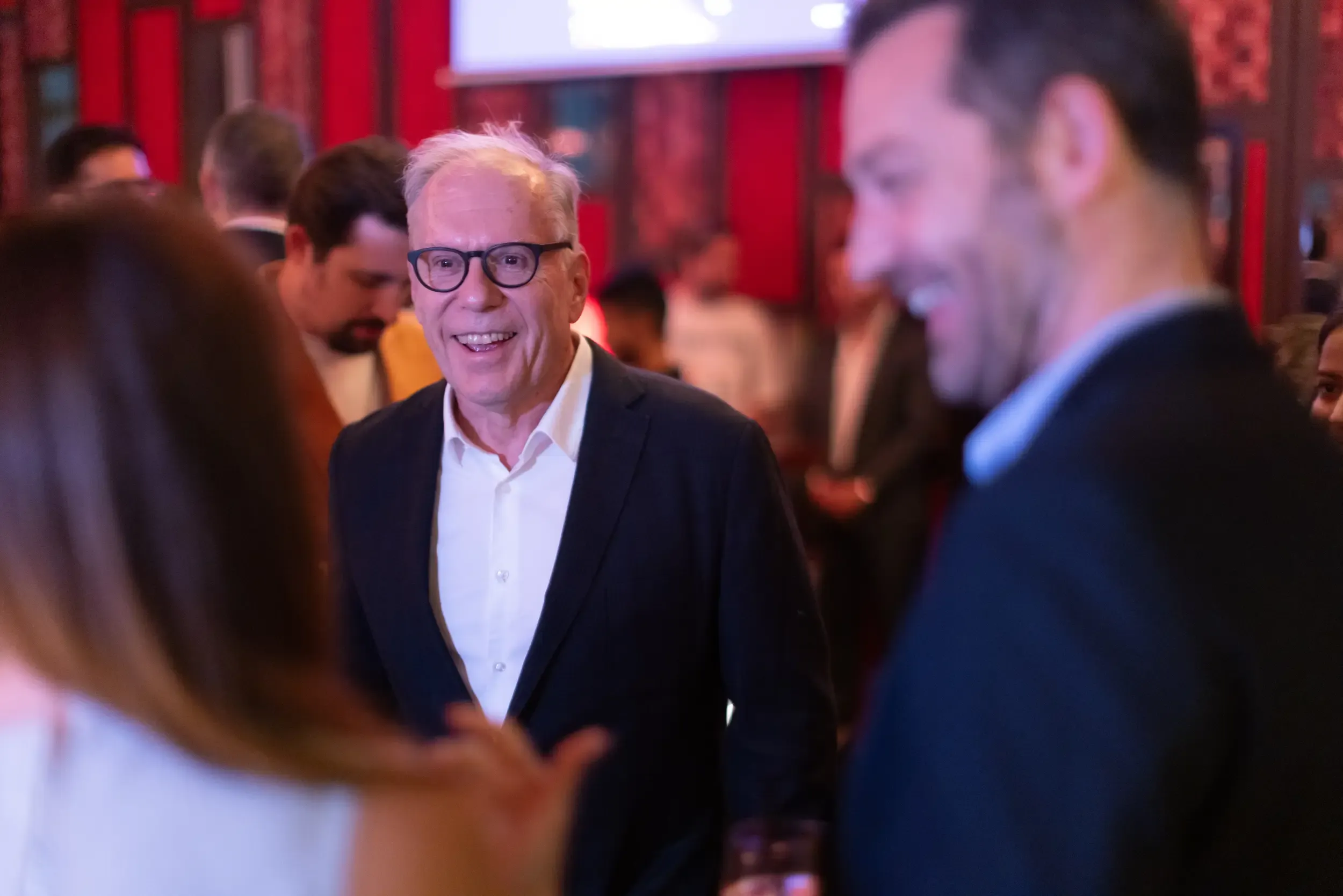 A smiling guest engaged in conversation at an evening reception.