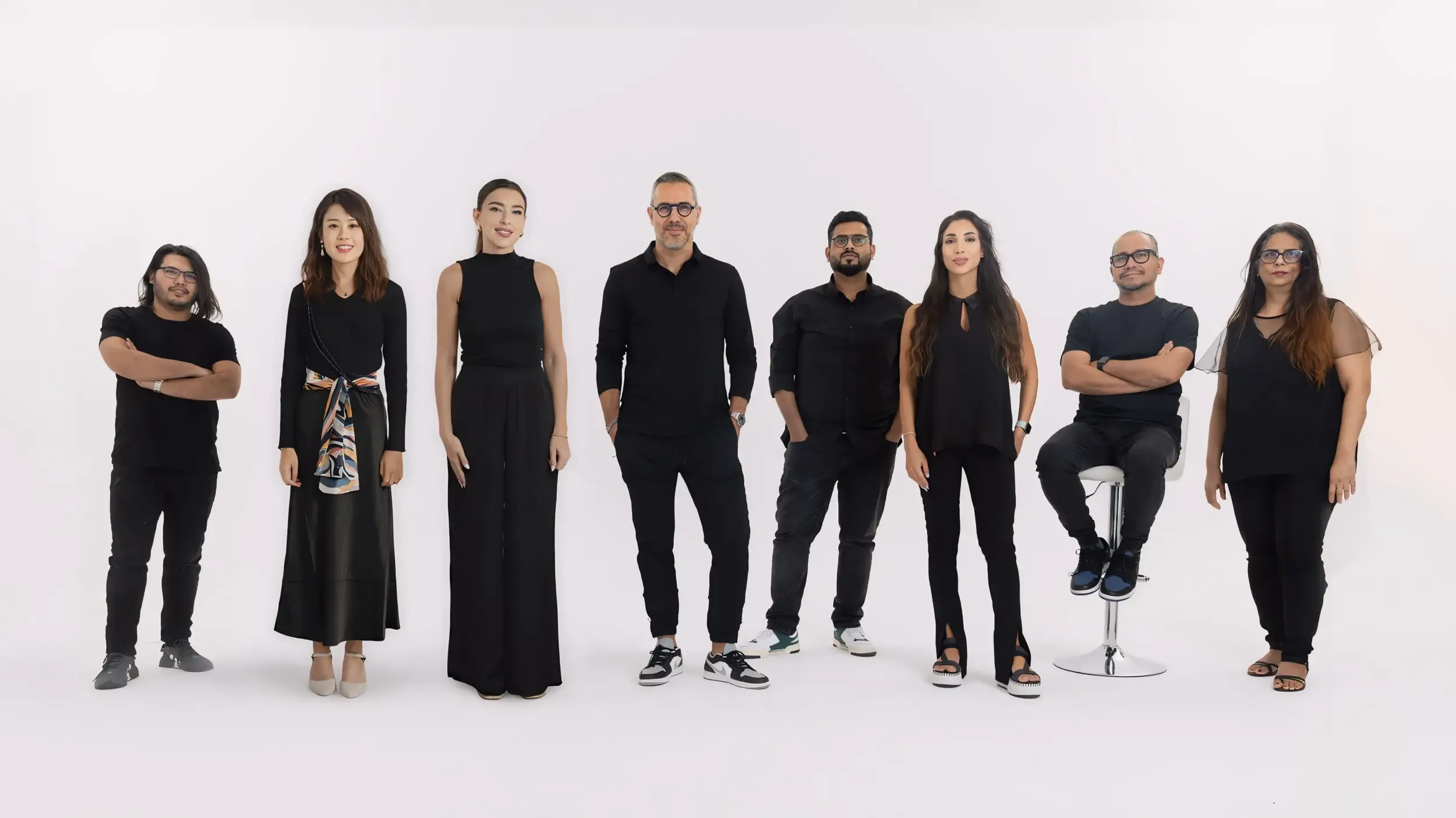 Eight-person Prospect Design team in coordinated black against a white studio backdrop