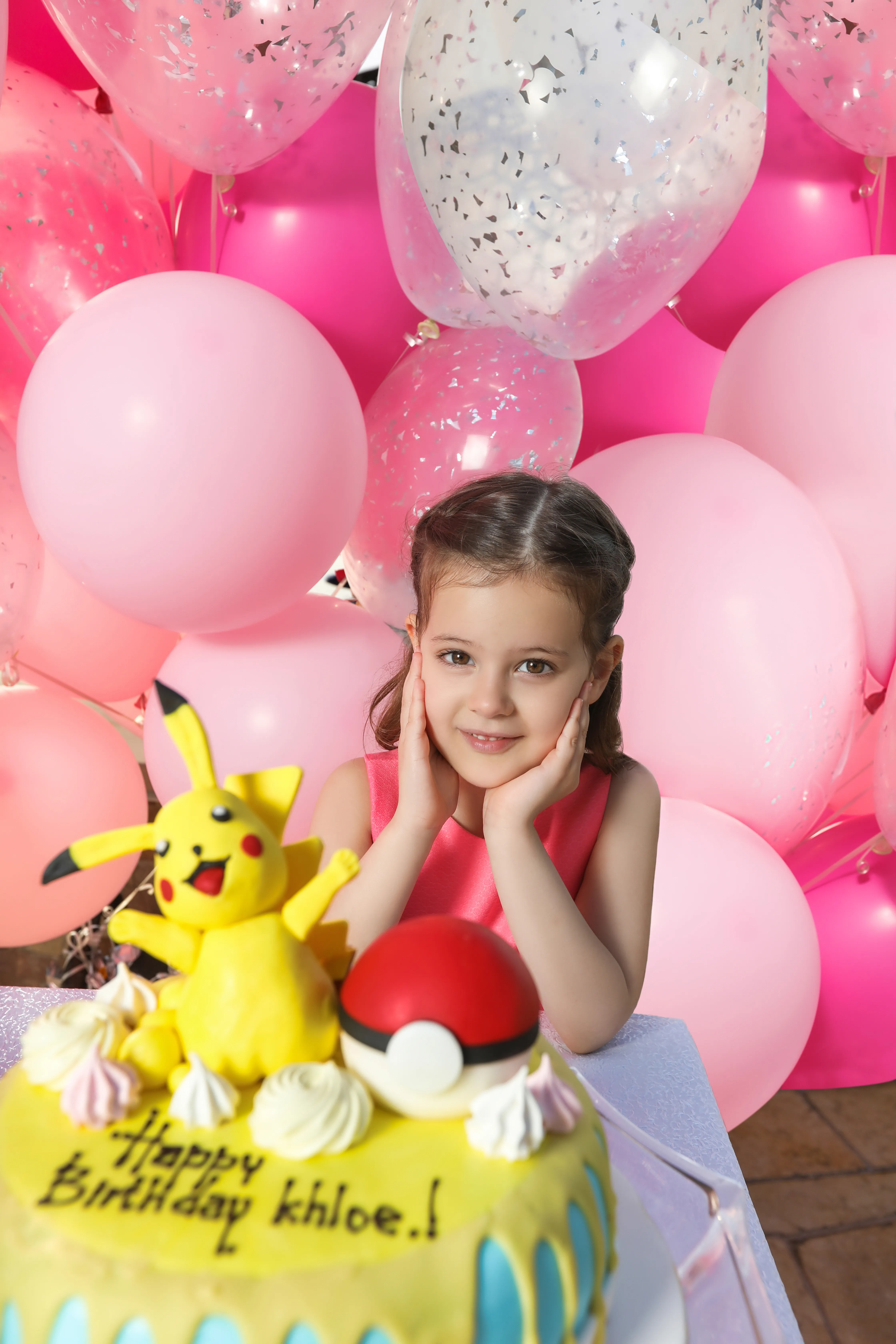 Child with Pikachu birthday cake and balloons (minor)