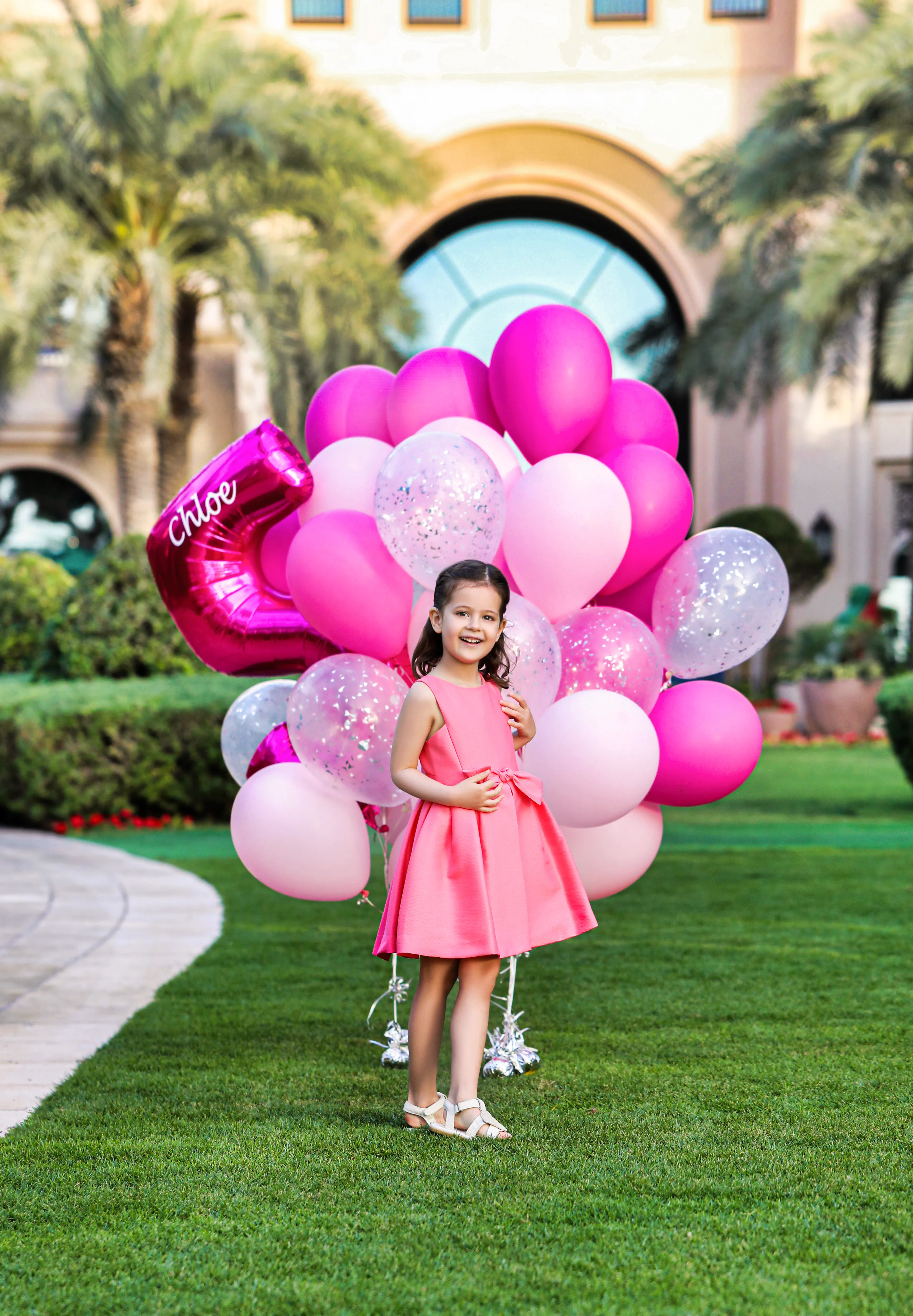 Girl with pink balloons on palace lawn (minor)