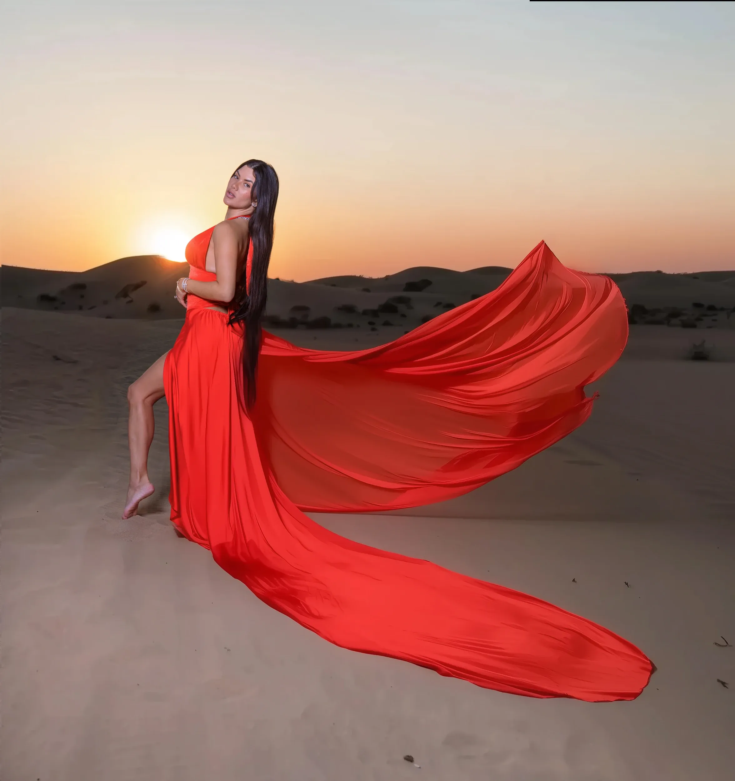 Red dress with sweeping train at desert sunset