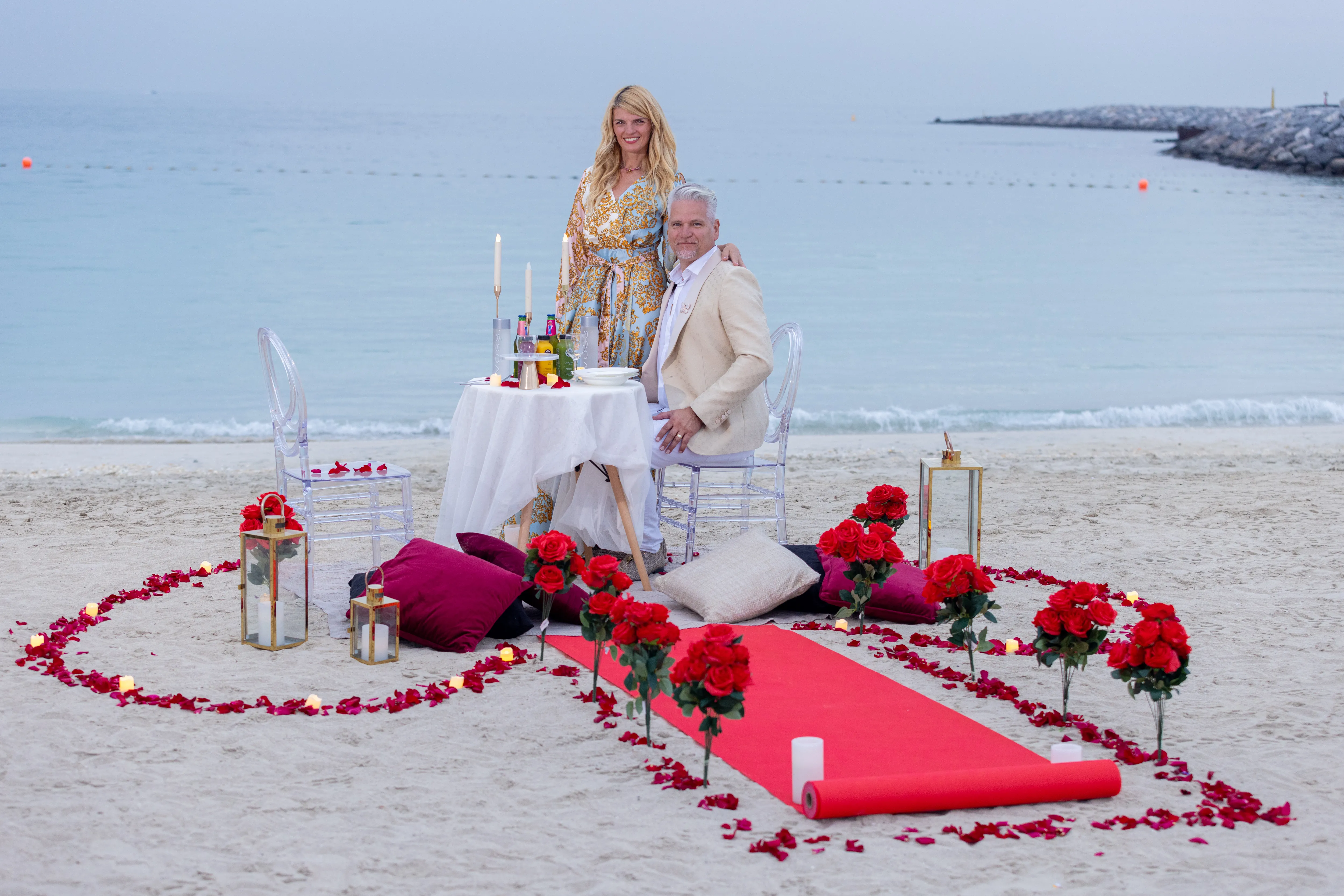 Beach proposal set-up with rose heart and dinner table