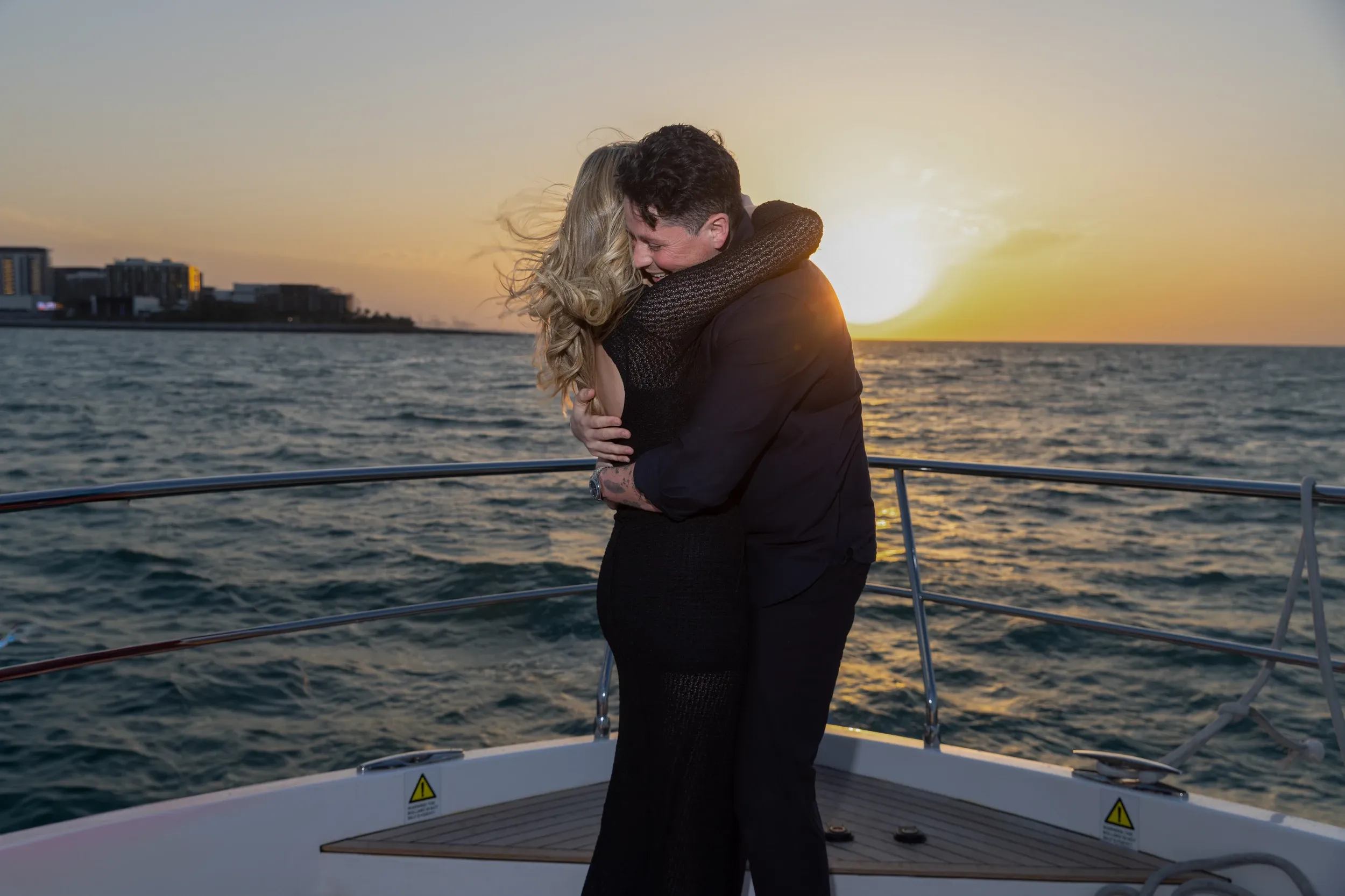 Couple embracing on a yacht off Dubai as the sun sets