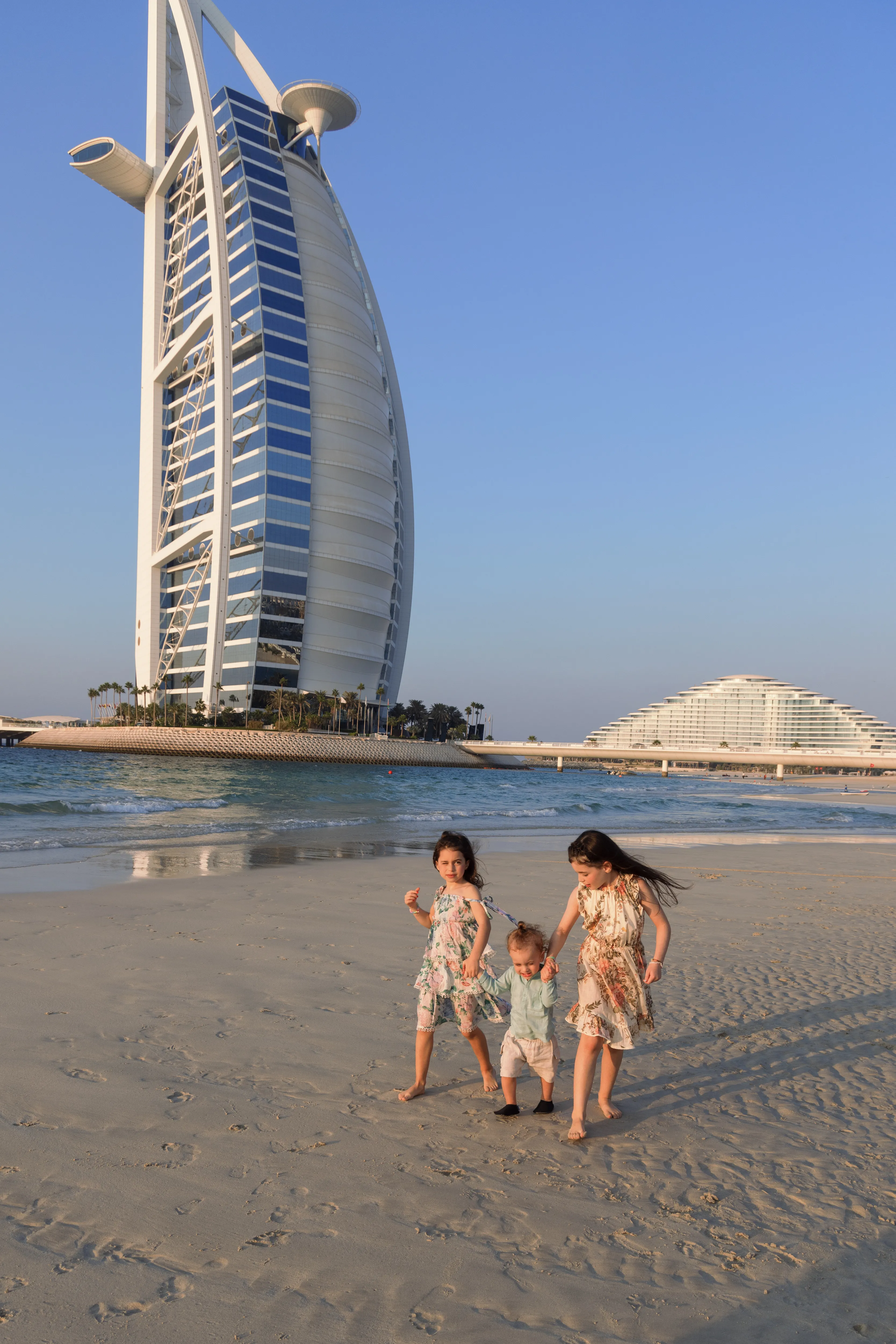 Mother and children on beach before Burj Al Arab