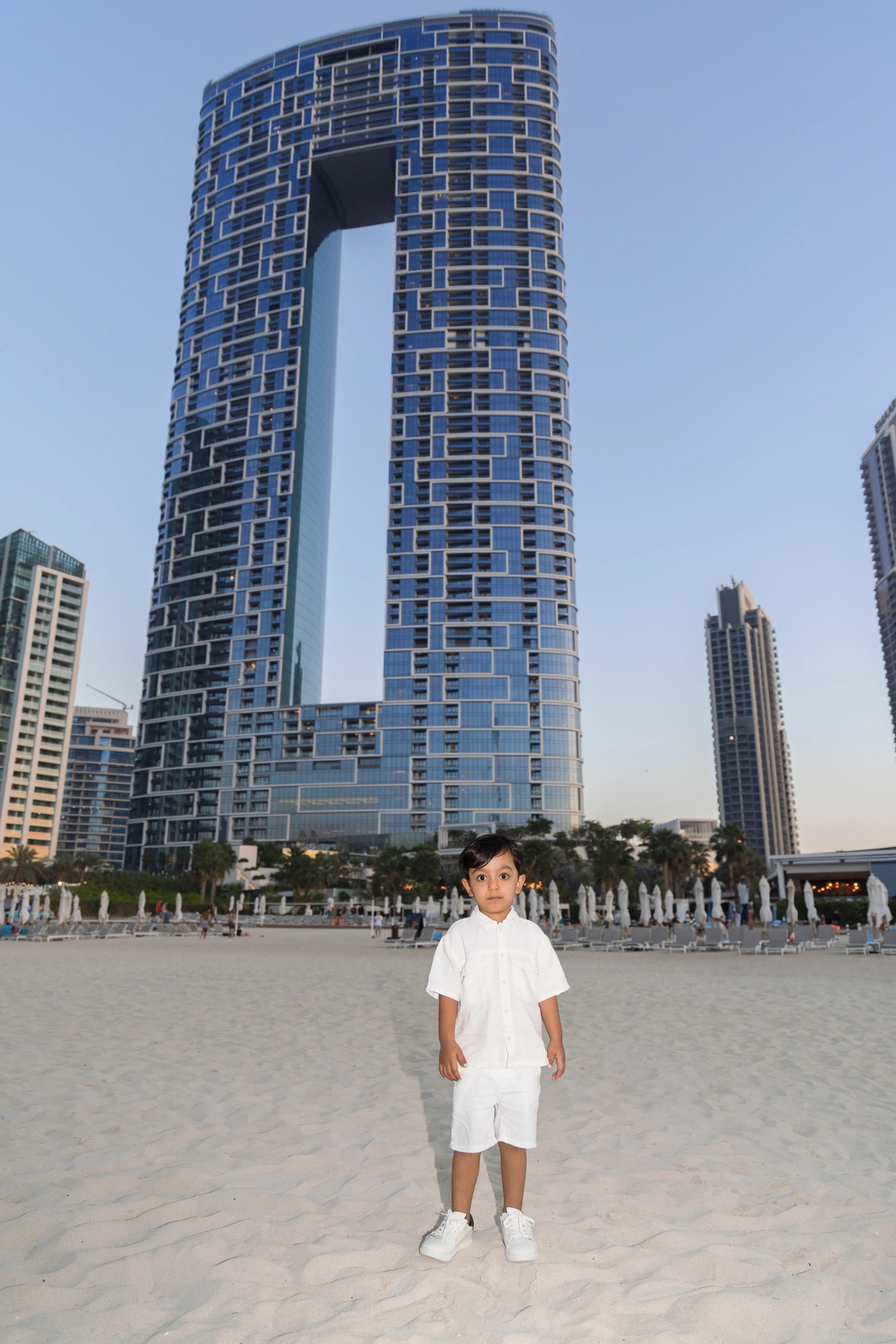 Boy on beach with tall tower behind