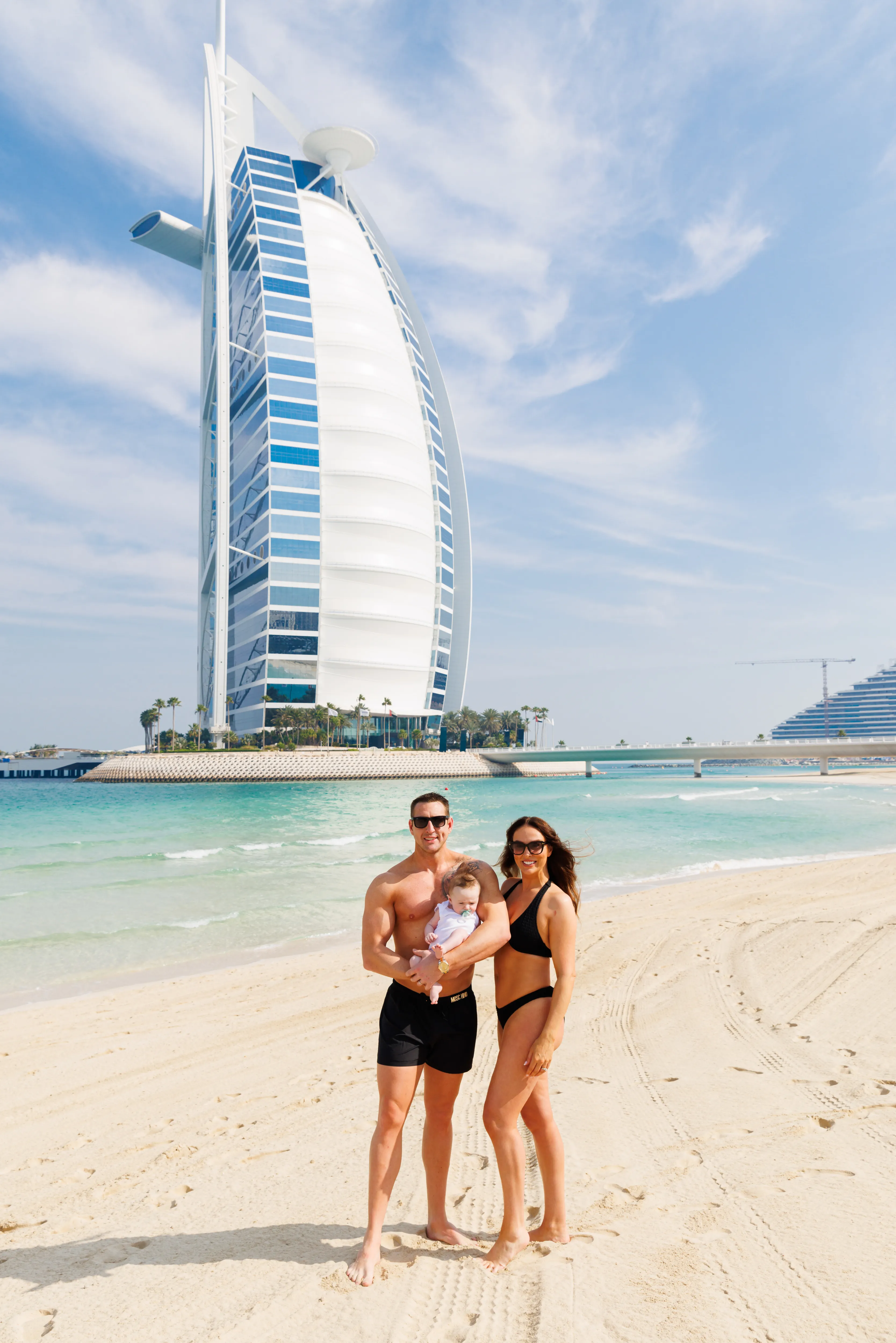 Couple with baby on beach before Burj Al Arab