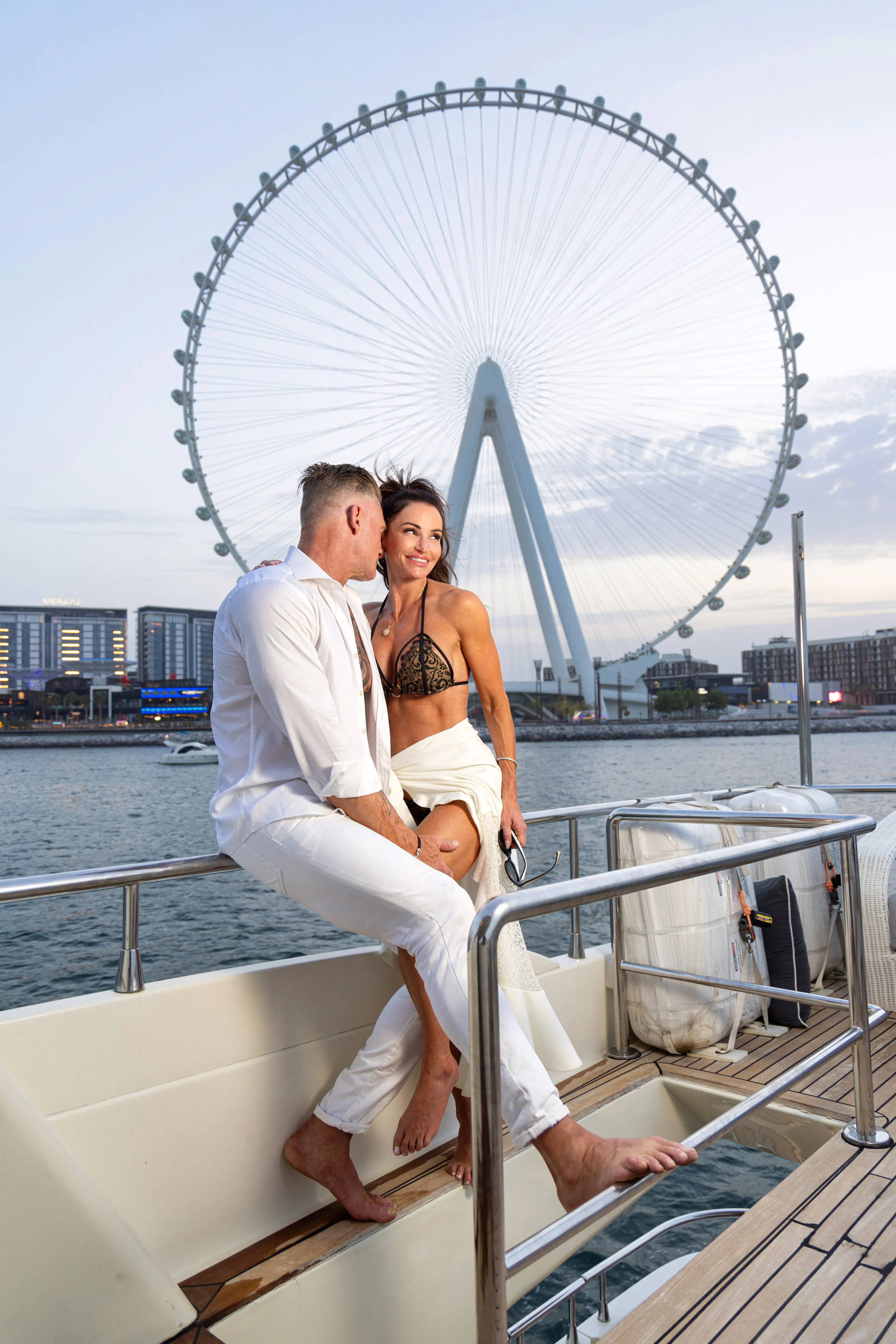 Couple on a yacht with Ain Dubai behind