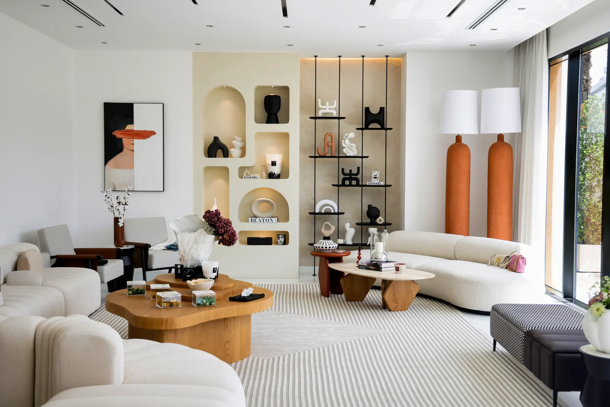 Bright modern living room with arched wall niches, sculptural shelving, organic sofa and a split-face painting