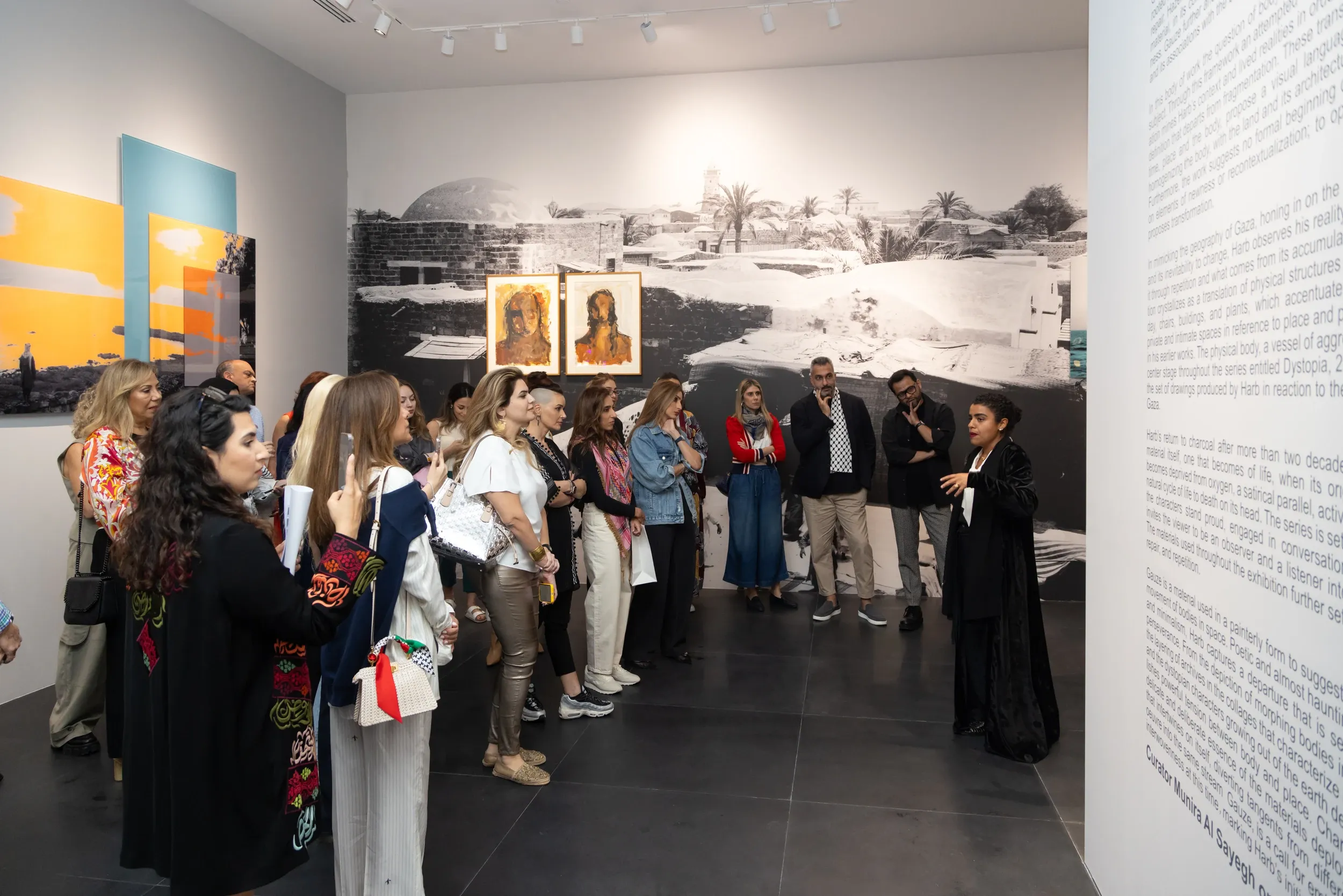 Visitors gathered around a speaker inside an art exhibition.