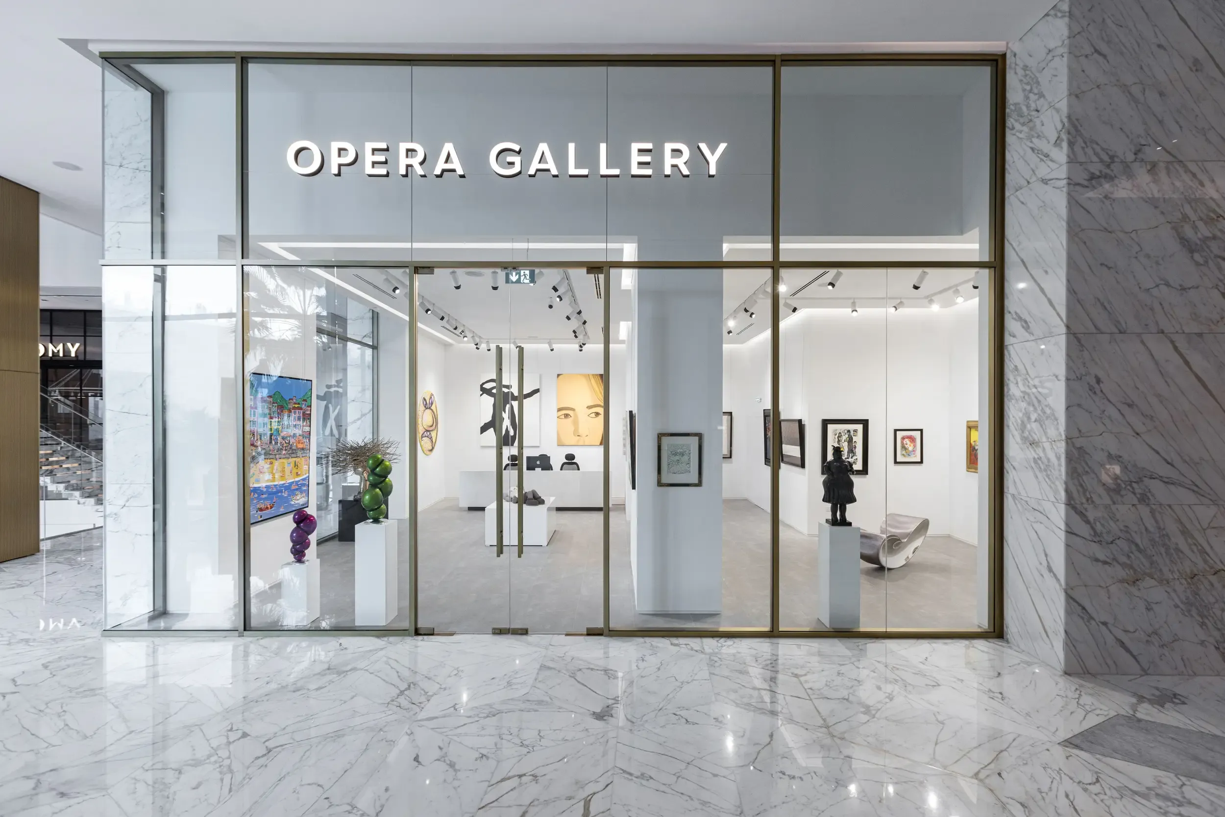 Wide exterior of Opera Gallery storefront at night