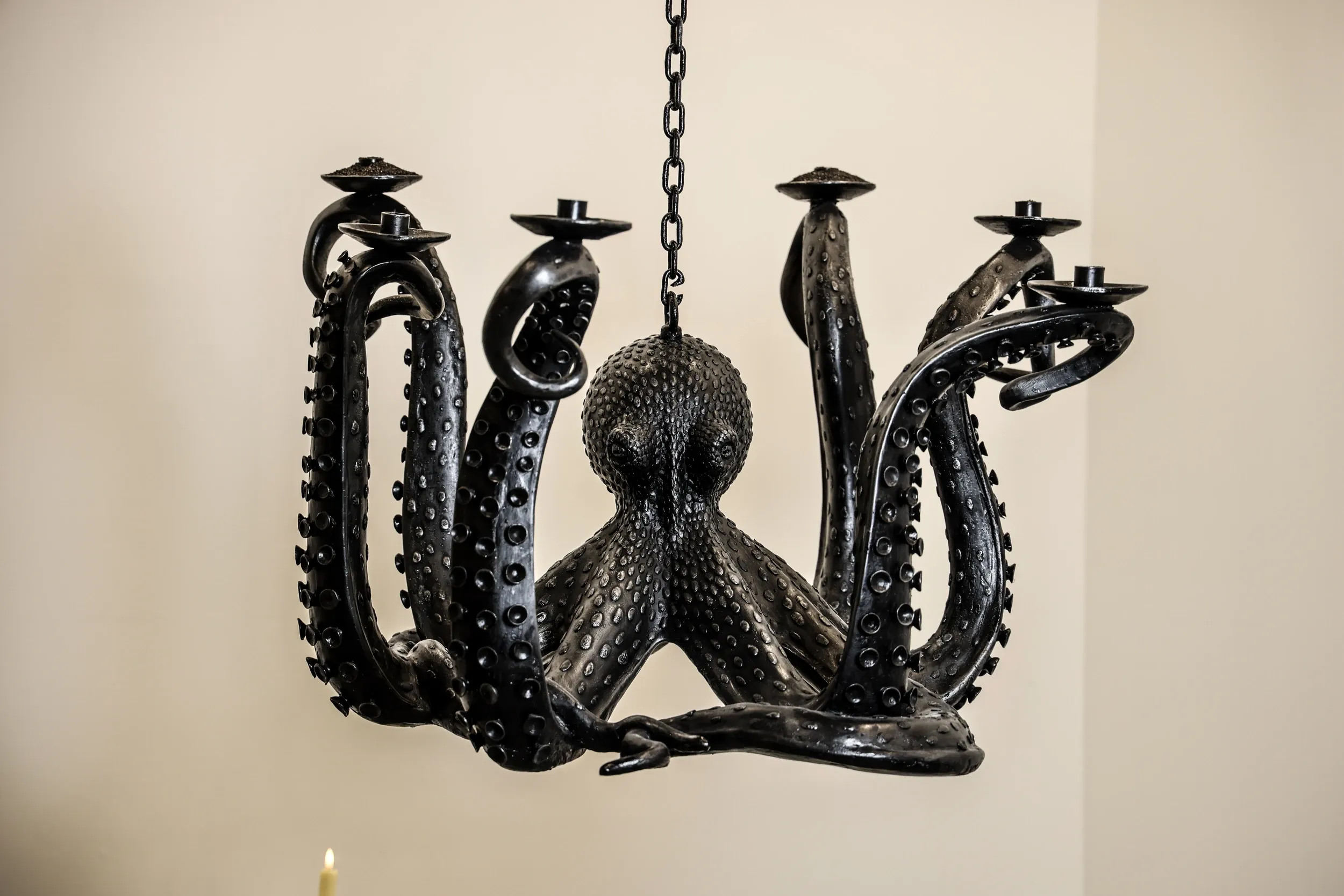 A black sculptural chandelier shaped with curling tentacles.