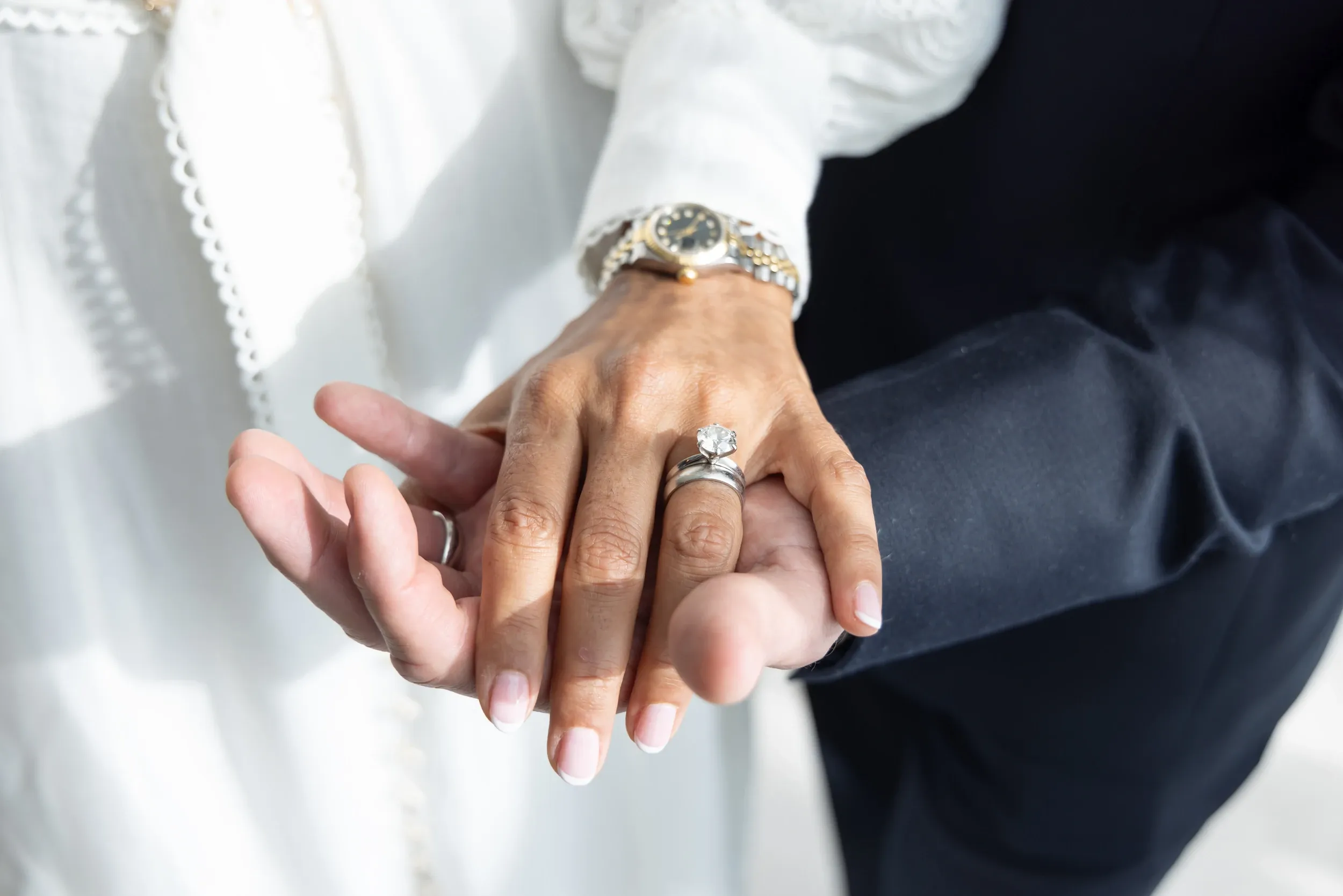 Close-up of a couple's hands displaying wedding rings.